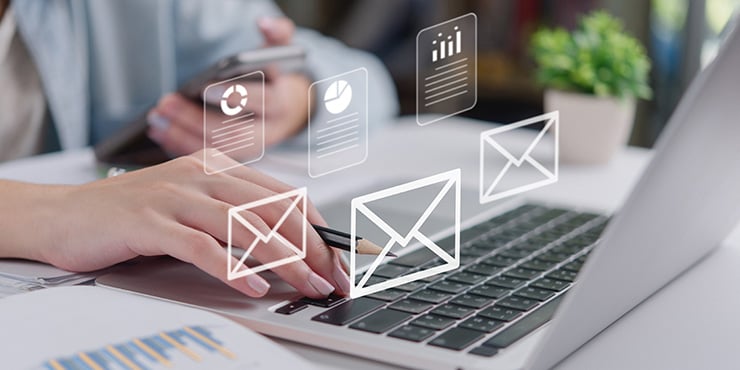 main de femme devant un ordinateur portable faisant du marketing email