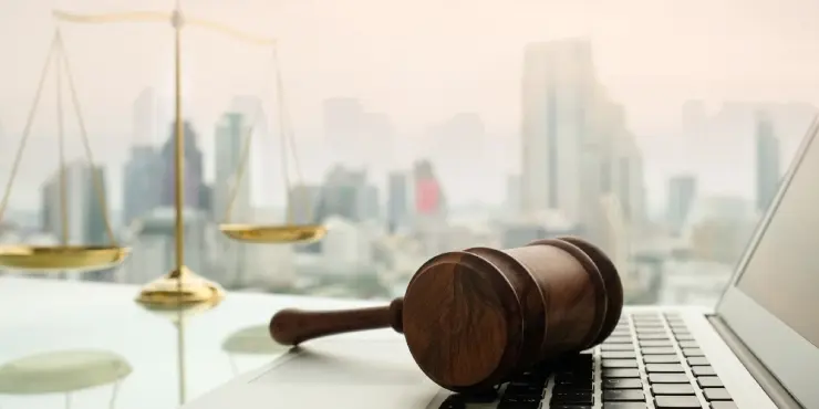 marteau de président légal sur un ordinateur portable avec une ville moderne en fond